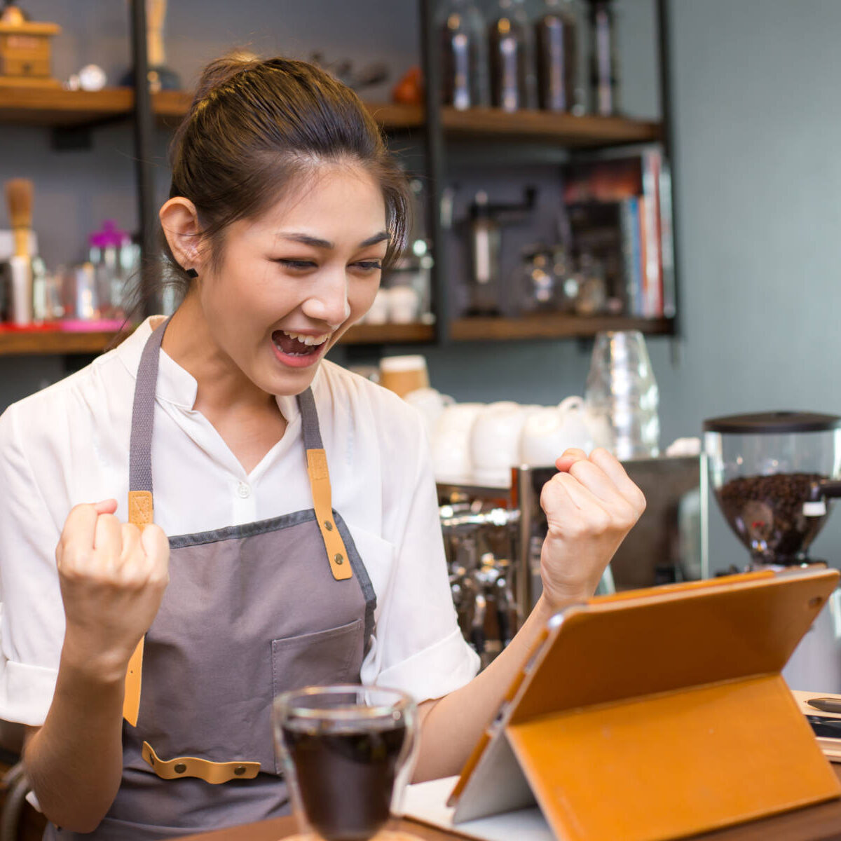 Asian barista woman using tablet for promote shop. Woman success for online marketing.