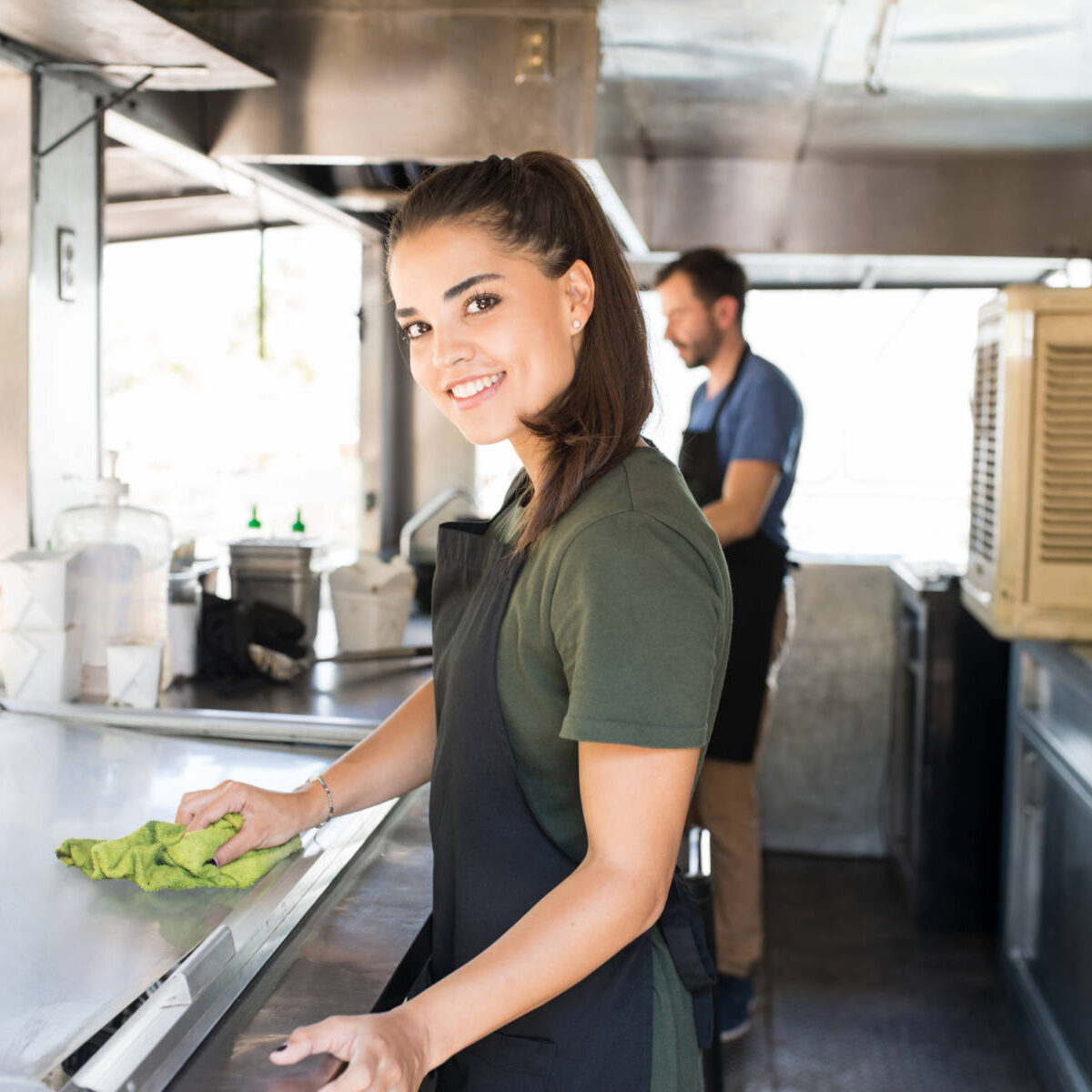 Portrait of a gorgeous cook cleaning her food truck and getting ready to prepare some food